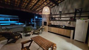 a kitchen with a refrigerator and a table and chairs at Casa do Sérgio lindo loft ideal para casa e pequena família,moderno e confortável in Paraty