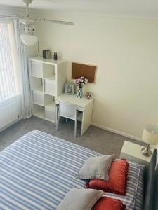ThundersleyにあるBlue Bungalowのベッドと机とテーブルのある寝室 +18枚の写真