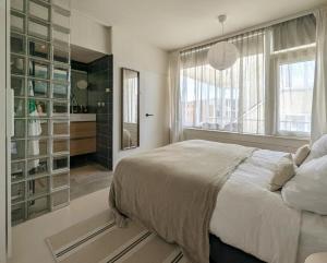 a bedroom with a bed and a large window at Strandstudio Lumare in Bergen aan Zee