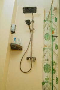 a bathroom with a shower with a phone on a wall at Artesano Park View Furnished Apartment in Nairobi