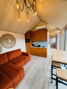 a living room with a couch and a kitchen at Zagroda Sosnowa in Dębki +7 photos