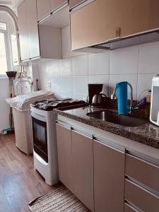 una cocina con fregadero y estufa en Acolhida Temporada, en Río de Janeiro