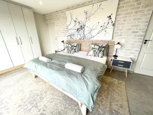 a bedroom with a large bed with a brick wall at Wild Comforts at Springerbaai in Boggomsbaai