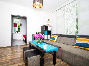 a living room with a couch and a table at Apartament Sopot Kamienny Potok in Sopot