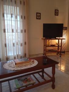 a living room with a coffee table and a flat screen tv at Watermelon Home in Nea Moudania