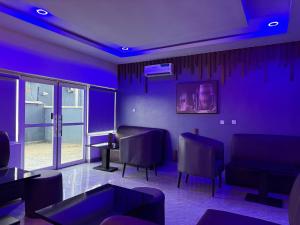 a blue room with chairs and a couch and a table at El-Patevadan Hotel and Suite in Yenagoa