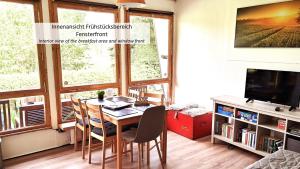 a dining room with a table and chairs and a television at Talblick 1 - Ihr Ferienhaus mitten im idyllischen Tal in Bad Bibra