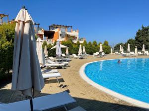 a swimming pool with an umbrella and lounge chairs and a resort at Italian charm, modern elegance in Pizzo in Pizzo