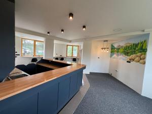 a large kitchen with a counter with blue cabinets at Hikers Paradise Hostel High Tatras in Železničná Stanica Štrba