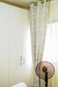 SyokimauにあるLuxore Rozina Airport View Apartment, Syokimau Nairobiの白いカーテンと窓の前にランプがある部屋