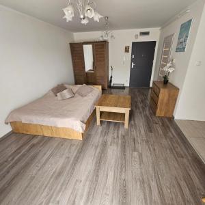 a bedroom with a bed and a wooden floor at Apartament Komorniki - Osiedla na Skraju Lasu in Komorniki