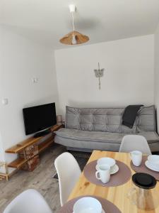 a living room with a couch and a table and chairs at Domki Letniskowe SZTORM in Jastrzębia Góra