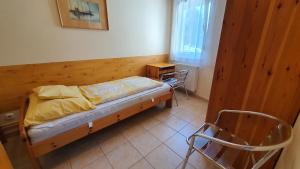 a small bedroom with a bed and two chairs at Holiday home in Szantod - Balaton 20221 in Szántód