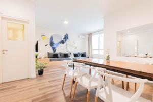 une salle à manger avec une table et des chaises blanches dans l'établissement Fliphaus Ayacucho 2 Bd en-suite in Recoleta, à Buenos Aires