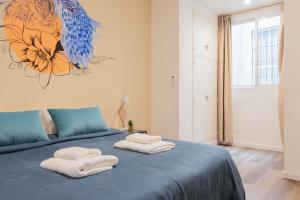 une chambre avec un lit bleu avec des serviettes dessus dans l'établissement Fliphaus Ayacucho 2 Bd en-suite in Recoleta, à Buenos Aires