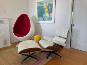une pièce avec deux chaises et une chaise rouge et blanche dans l'établissement Lakefront midcentury vintage, à Island Pond
