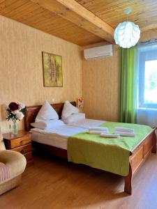 a bedroom with a large bed with a green blanket at Akmuo Ant Akmens in Šventoji