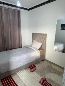 ein kleines Schlafzimmer mit einem Bett und einem Teppich in der Unterkunft Dakhla Surf School & Lodge in Oulad Akkou