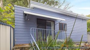 a purple tiny house with a balcony in a yard at Studio 21 in Nelson Bay +4 photos