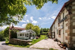 une serre dans un jardin à côté d'un bâtiment dans l'établissement vaquero casa rural alquiler completo, à Abiada