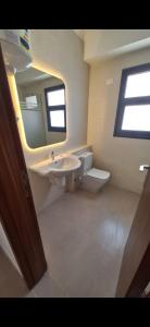 a bathroom with a sink and a mirror and a toilet at Luxurious Chalet GAIA Ras El Hekma North Coast in Zāwiyat al ‘Awwāmah +6 photos