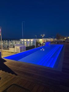 a large blue swimming pool at night at Hotel Gradara in Bellaria-Igea Marina