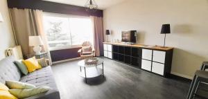 a living room with a couch and a tv at Type 2 Catho Esa in Angers +3 photos