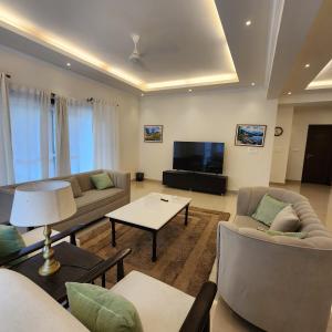 a living room with couches and a flat screen tv at Fari villa-Luxury Stay & Pool in Moinabad +21 photos