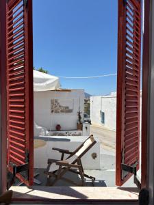a chair sitting on the porch of a house at Venduri House in Péran Triovasálos