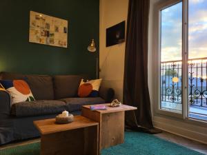 ナントにあるStudio cosy proche gare et jardin des plantes classé 2 étoilesのソファと窓のあるリビングルーム