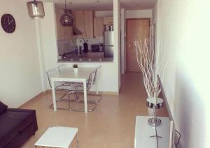 a living room with a table and a kitchen at Torres in Roldán