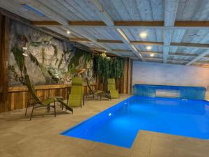 a pool in a room with chairs and a painting at Hotel Roklina in Hrabušice