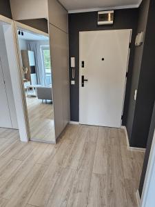 pasillo con puerta blanca y espejo en Apartament z widokiem na las, en Ustka