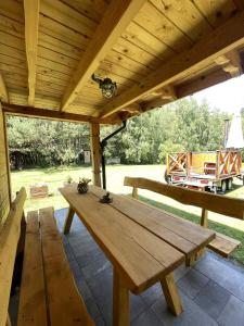 a wooden picnic table under a wooden roof on a patio at Chatka przy lesie Roztocze Szewnia Dolna 74 22-442 in Szewnia