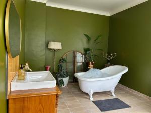 a green bathroom with a tub and a sink at Singel room in big house in Molkom