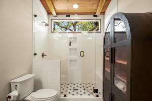 a bathroom with a toilet and a shower with a window at Live Oak Hideaway in Austin +51 photos