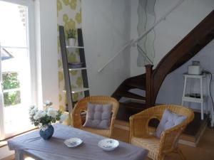 a living room with a table and chairs and a staircase at Gîte à la ferme in Renansart +2 photos