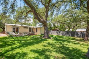 a yard with trees and a house at Live Oak Hideaway in Austin