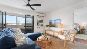 een woonkamer met een blauwe bank en een tafel bij Lakeview Retreat in Culburra Beach