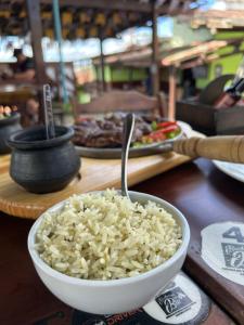 eine Schüssel Reis auf einem Tisch mit Essen in der Unterkunft Flat - Condomínio Brisa da Serra - Gravatá in Gravatá