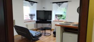 a room with a desk and a chair and a television at Apartament na Sienkiewicza in Leśna +2 photos