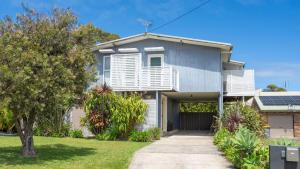 een huis met witte luiken en een oprit bij Lakeview Retreat in Culburra Beach