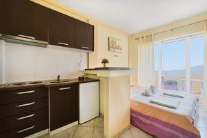 a kitchen with a counter and a bed in a room at Apartment Dragicevic 5 with Garage in Budva