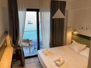 a bedroom with a bed with a view of the ocean at Thalassea Apartments in Himare