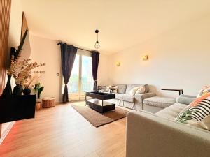 a living room with a couch and a table at Maison rénové 10 prsn Parking privée & Balcon Proche Gare-Viotte in Besançon