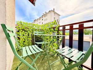 two chairs and a table on a balcony at Maison rénové 10 prsn Parking privée & Balcon Proche Gare-Viotte in Besançon