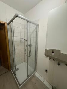 a shower stall with a glass door in a bathroom at Platin Apartment in Wuppertal