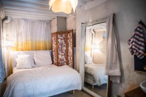 - une chambre avec un miroir à côté d'un lit dans l'établissement Charm and comfort, à La Celle-sous-Gouzon