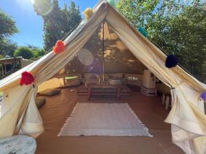 a canvas tent with a table and chairs in it at GLAMPING RANCHO ALEGRE in Merlo