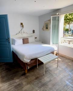 a bedroom with a large white bed and a window at Chambre d'hôtes Hôte des Portes Île de Ré in Les Portes